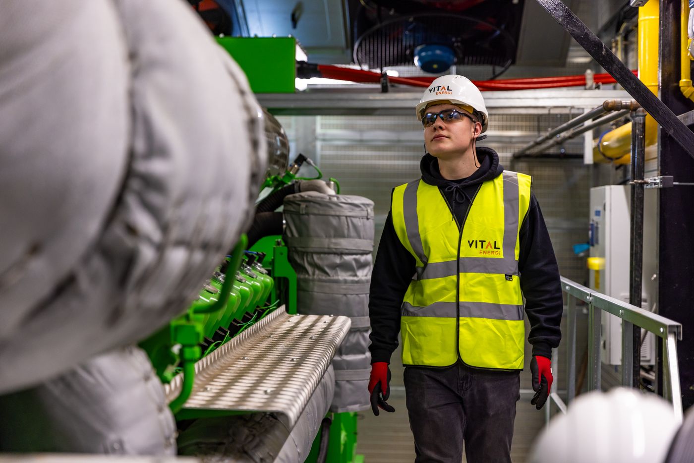 A technician inspecting machinery on a plant floor